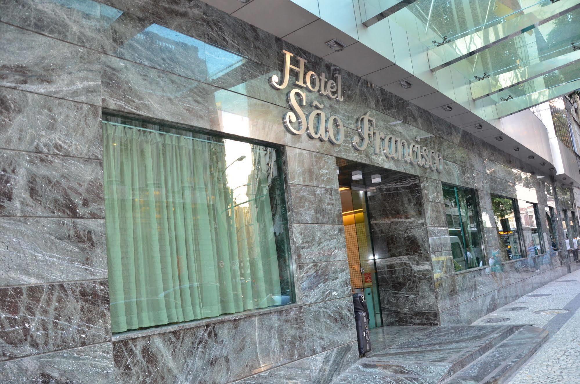 Hotel Atlantico Tower Rio de Janeiro Exterior photo The photo shows the exterior of a hotel named "Hotel São Francisco." The facade is made of marble, giving it an elegant appearance, and large glass windows are visible, likely allowing natural light to enter the interior. There are light green curtai